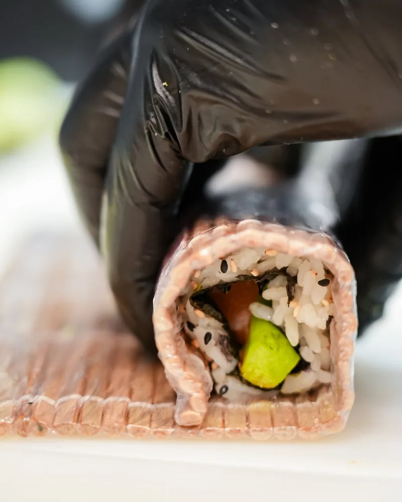 Les mains du maître sushi façonnant un maki dans la cuisine de Sushi Wa, Ixelles